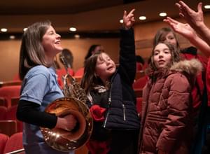 Photograph of French Horn player Elspeth Dutch talking with children