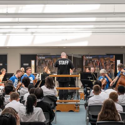 Photograph of a man conducting CBSO musicians during a performance at Shireland CBSO Academy.