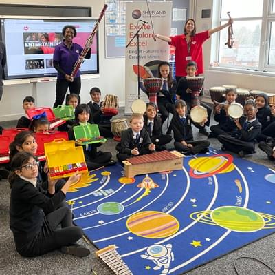 Photograph of CBSO players, a school teacher and their class with percussion instruments