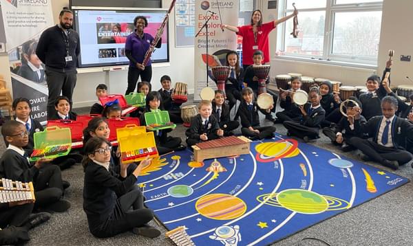 Photograph of CBSO players, a school teacher and their class with percussion instruments