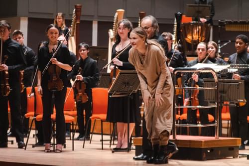 Photograph of composer Bergrún Snæbjörnsdóttir taking a bow with the CBSO Youth Orchestra.