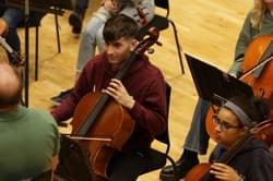 Photo of a young man playing the cello in the CBSO Youth Orchestra