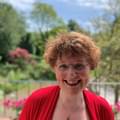 Headshot of harpist Katherine Thomas. Katherine is outside surrounded by greenery.