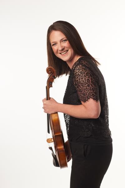 Photograph of Amy Thomas smiling whilst holding her viola