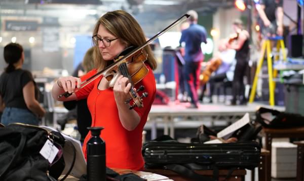 Photograph of Amy Thomas tuning her viola at Hockley Social Club