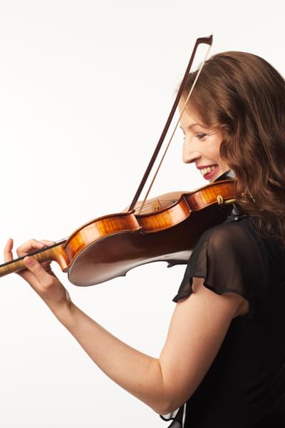 Photograph of Bryony Morrison smiling whilst she plays her violin