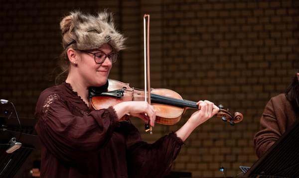 Photograph of Charlotte Skinner performing whilst wearing a cat mask as part of a Relaxed Concert