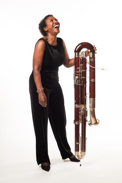 Photograph of Margaret Cookhorn laughing whilst holding her contrabassoon