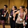 Photograph of the Learning and Engagement team laughing and dancing together during a schools' workshop