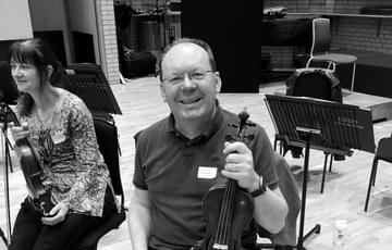 Stephen Maddock holding a violin at the Strings Playalong Day 2019