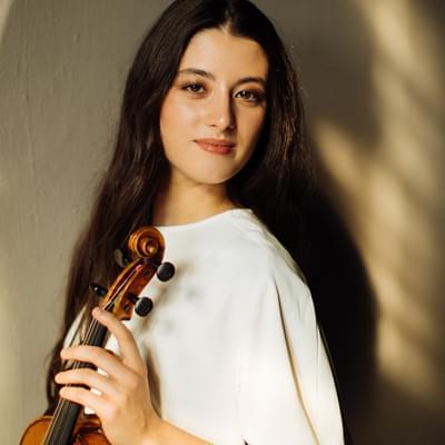 Photograph of María Dueñas holding her violin.