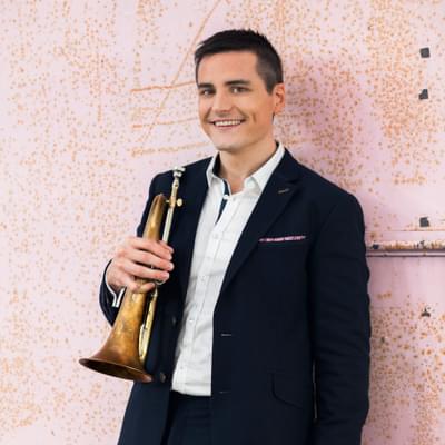 Photograph of Niall O'Sullivan smiling and holding a flugel horn.