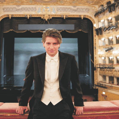 Photograph of Daniele Rustioni in white tie at an opera house.