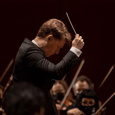 Photograph of Joshua Weilerstein conducting.