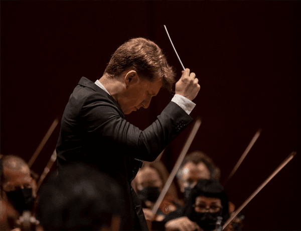 Photograph of Joshua Weilerstein conducting.