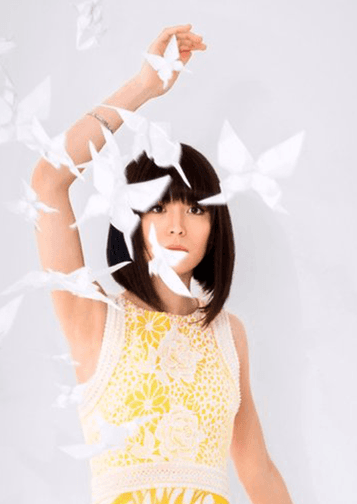 Headshot of Alice Sara Ott surrounded by white paper butterflies.
