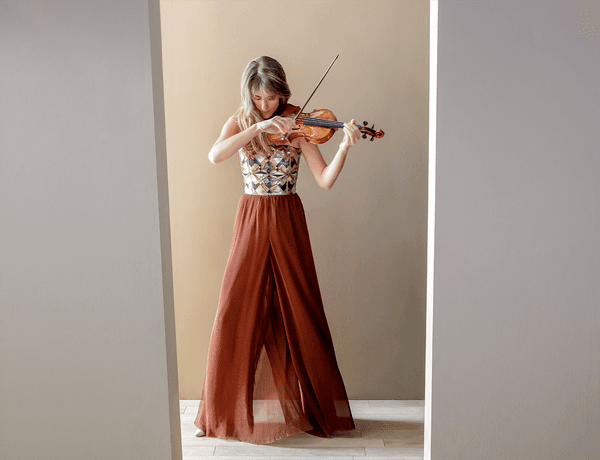 Photograph of Francesca Dego playing the violin whilst wearing a ball gown.