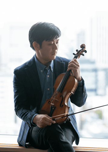 Photograph of Daishin Kashimoto holding his violin.