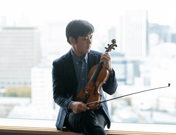 Photograph of Daishin Kashimoto holding his violin.