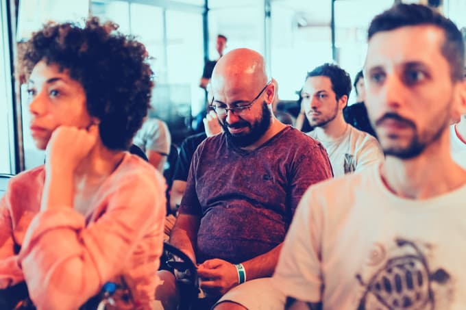 Various people sitting, presumably watching a work presentation.