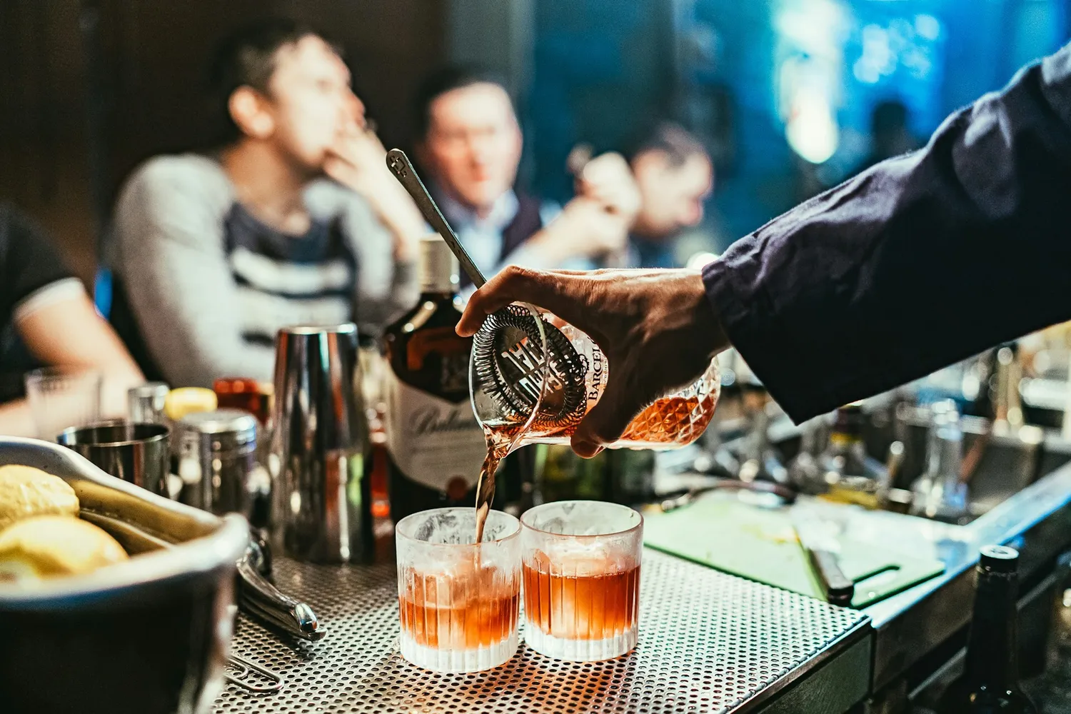 Bar tender pouring cocktails for guests