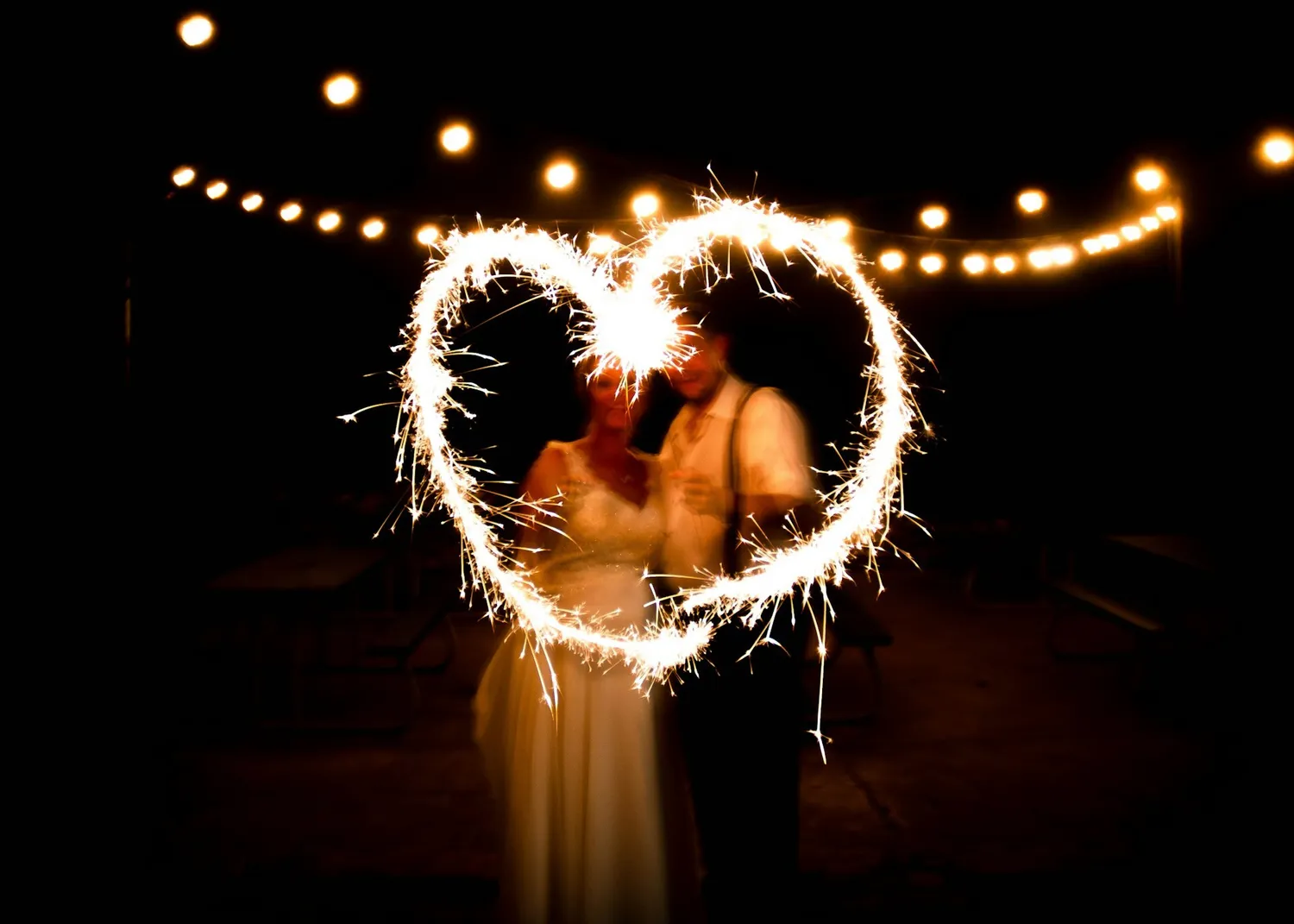Couple drawing a heart with ice fountains