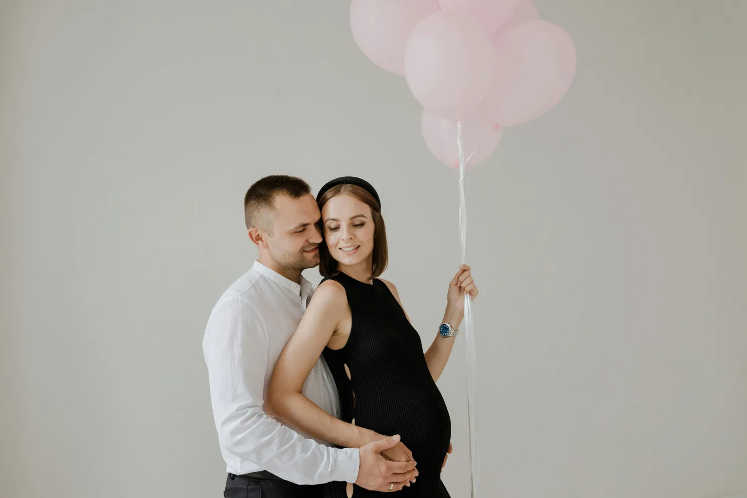Couple holding balloons gender reveal