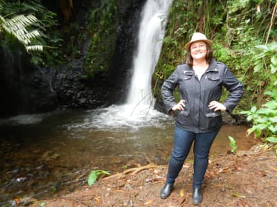 Liz pictured in front of waterfall during a trip to Kenya with family.