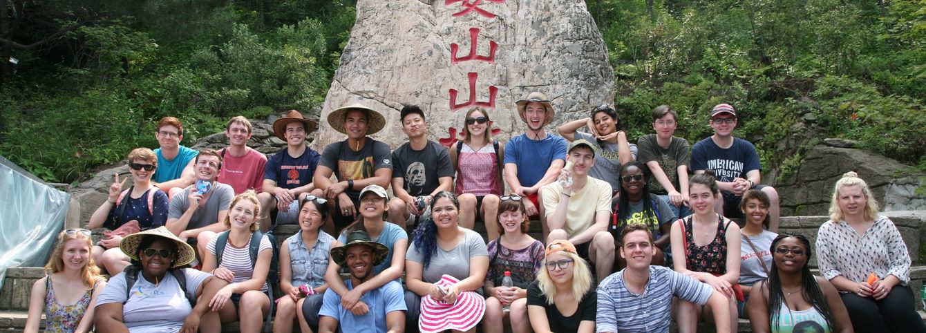 A large cohort poses in front of a monument in Taiwan.