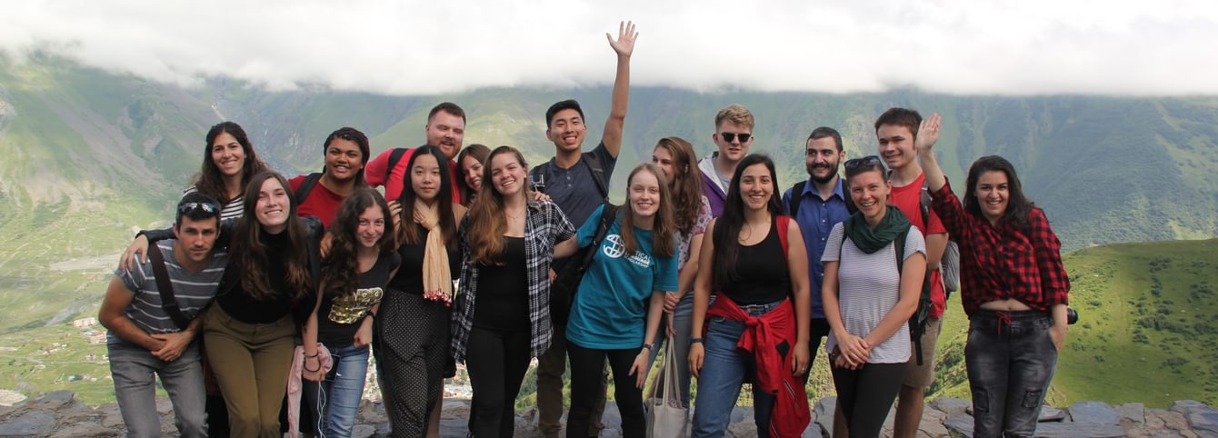 A group of CLS students pose in front of mountains in Georgia.