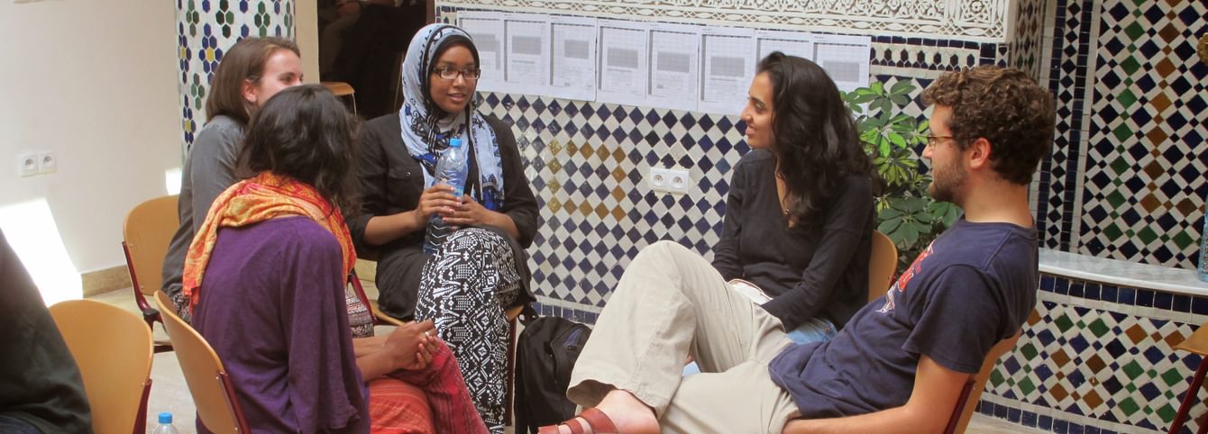 Five CLS participants sit in a circle and chat during a group activity in Morocco.