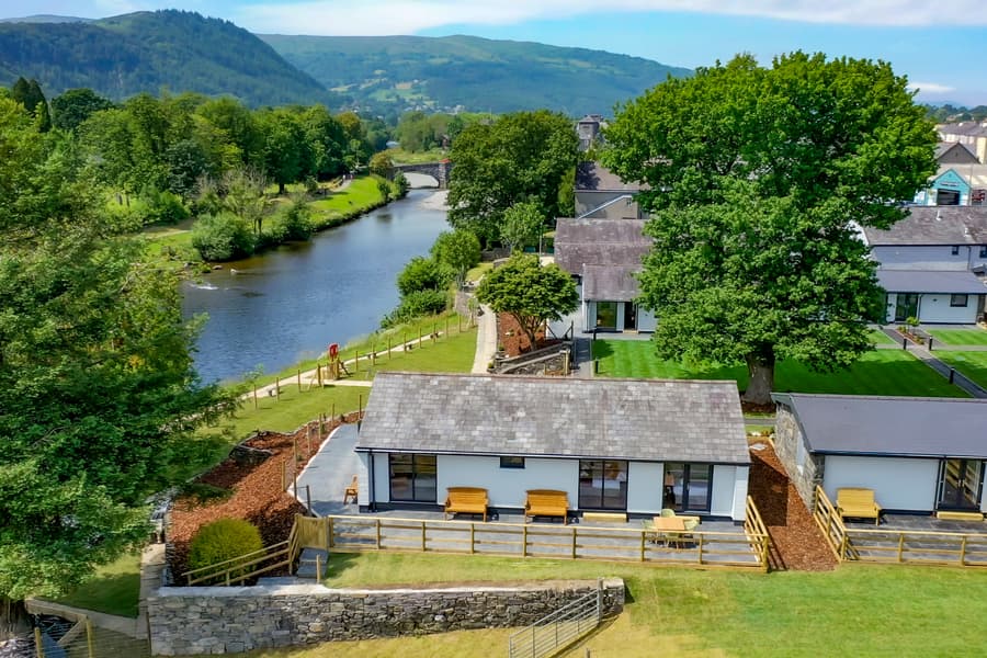 Drone footage of holiday lodges on the river Conwy and the Snowdonia mountains in the background