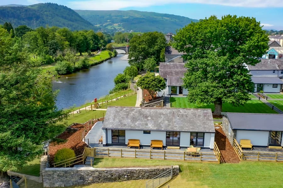 Drone footage of holiday lodges on the river Conwy and the Snowdonia mountains in the background