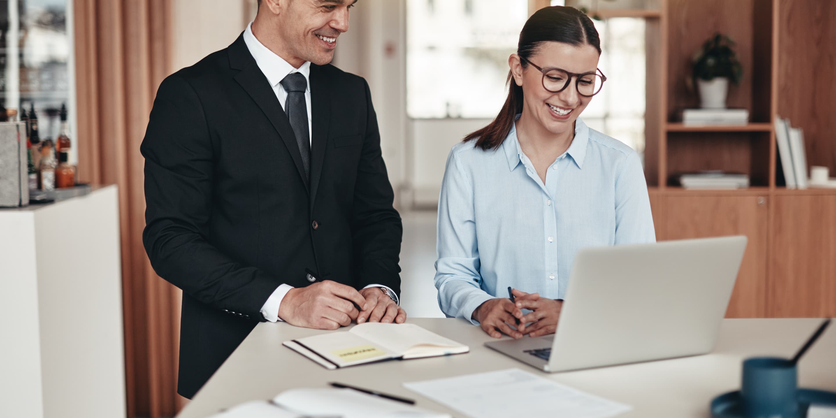 Two smiling businesspeople working together in an CBJT9 NB