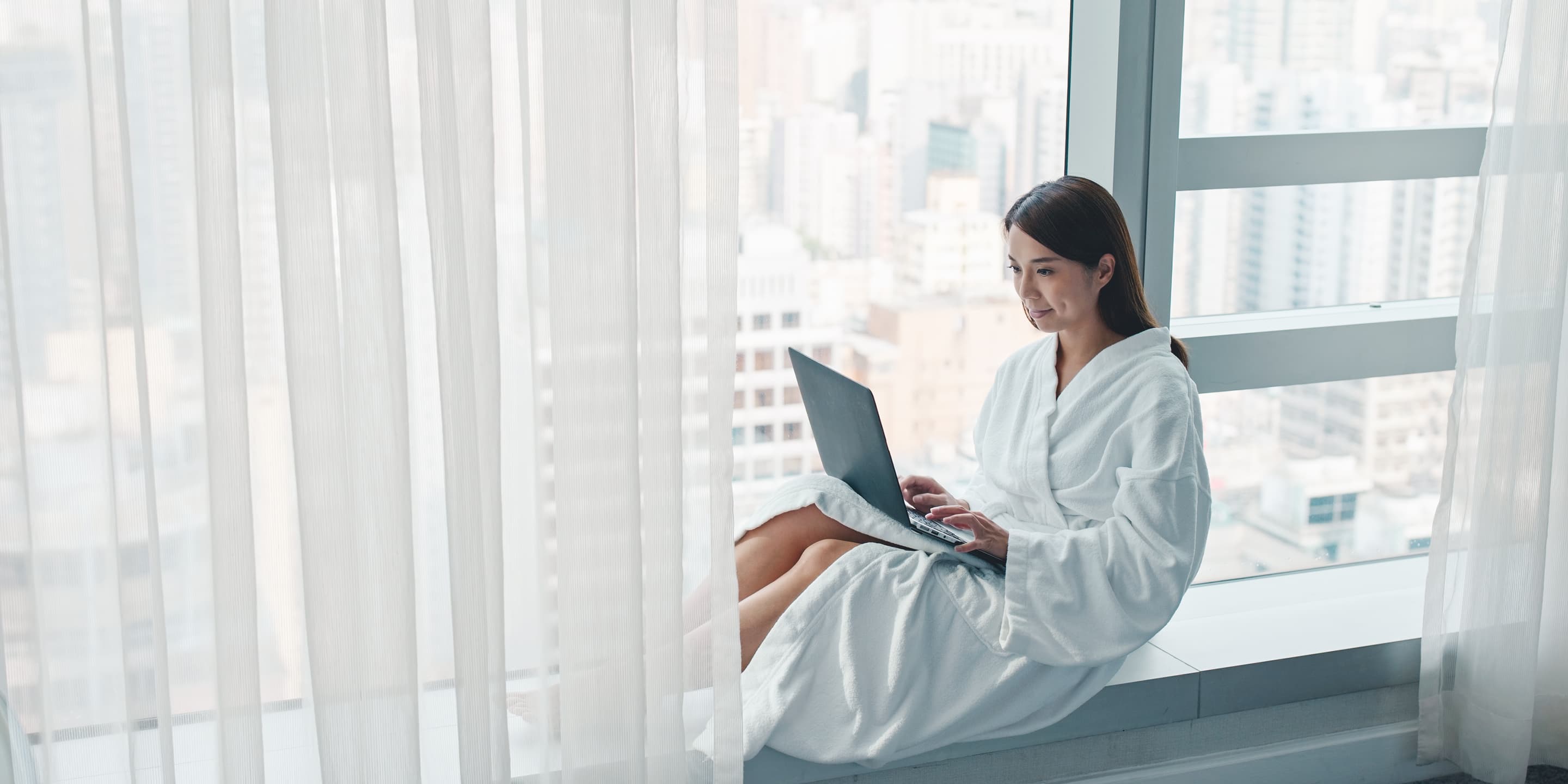 Woman work on laptop computer in hotel room CSSLVXY