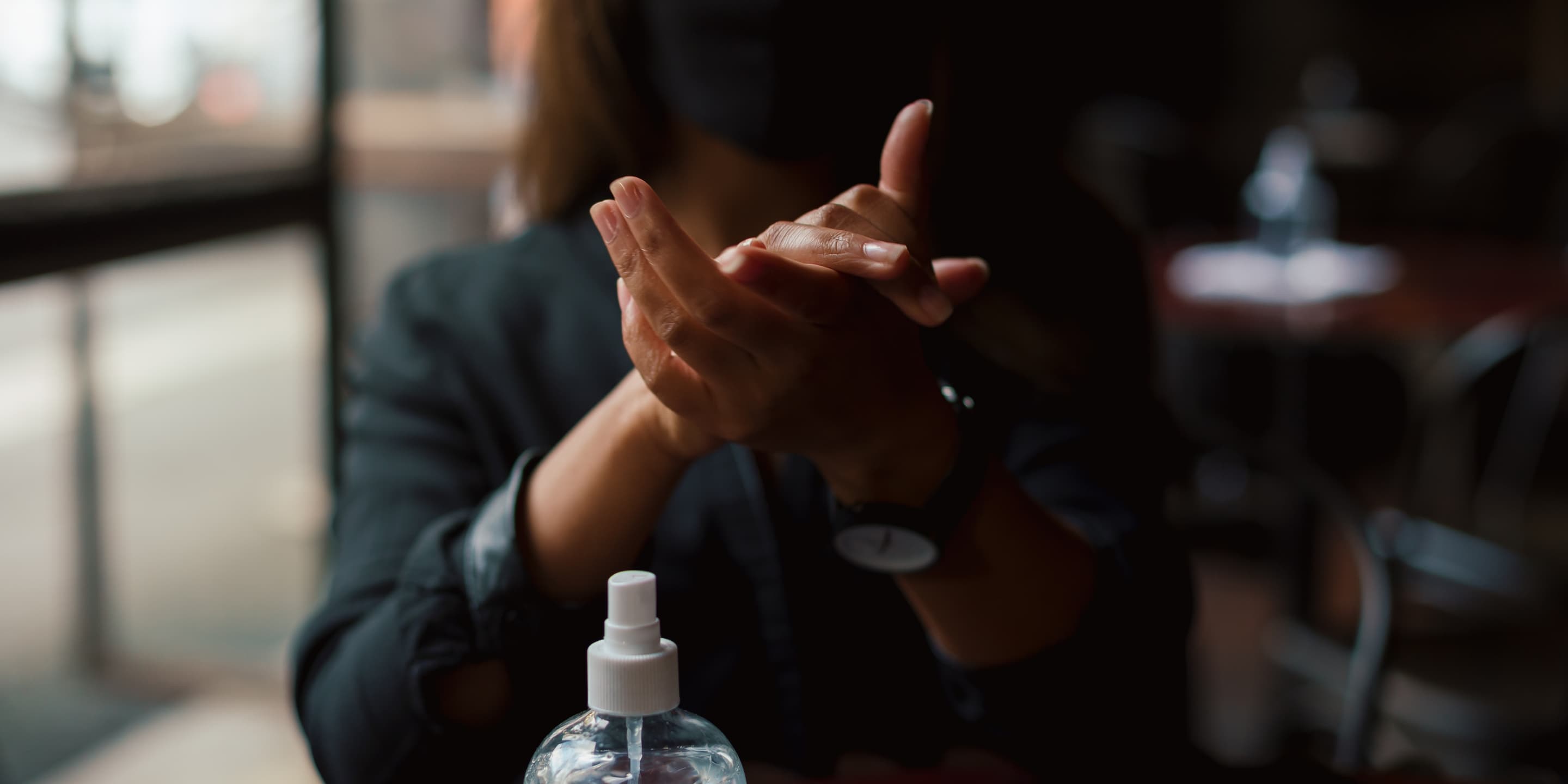 Young woman washing hands with sanitiser in coffee MPEXNMF
