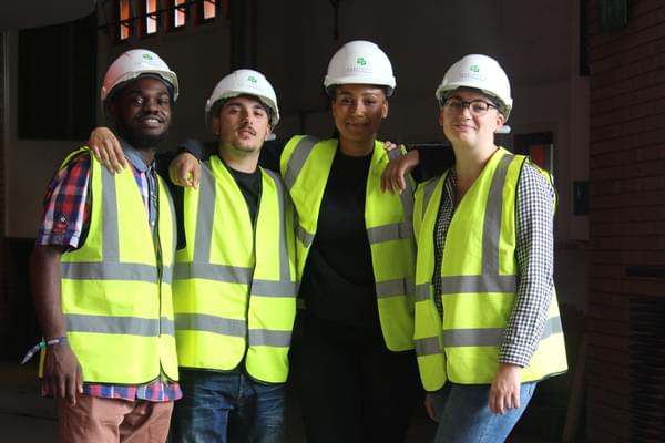 A group of young consultants in high viz vests and hard hats