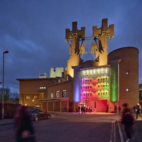 An image of the Contact building at dusk lit up in rainbow colours