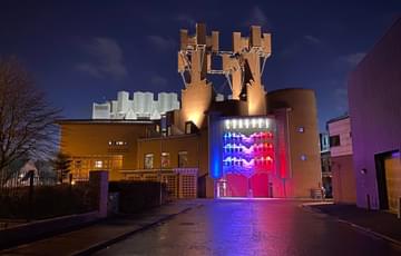 Contact's castle-like exterior at night lit up in blue and pink and purple lights