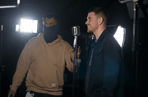 Two men chat in a filming studio