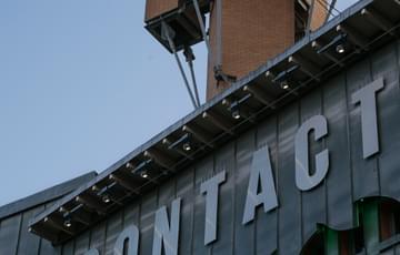 A low shot of Contact's steel facade against a light blue sky