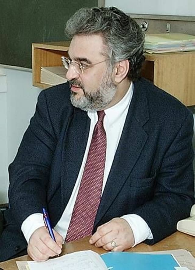 Dr. Anthony Ordman sitting at his desk in a suit.