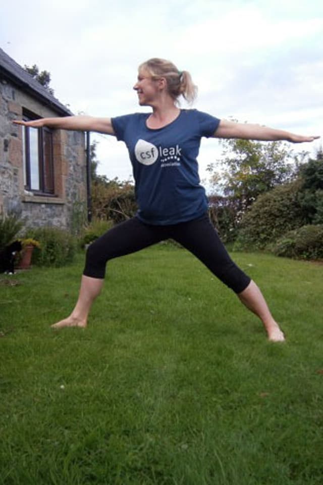 A woman doing yoga with a CSF Leak Association shirt.