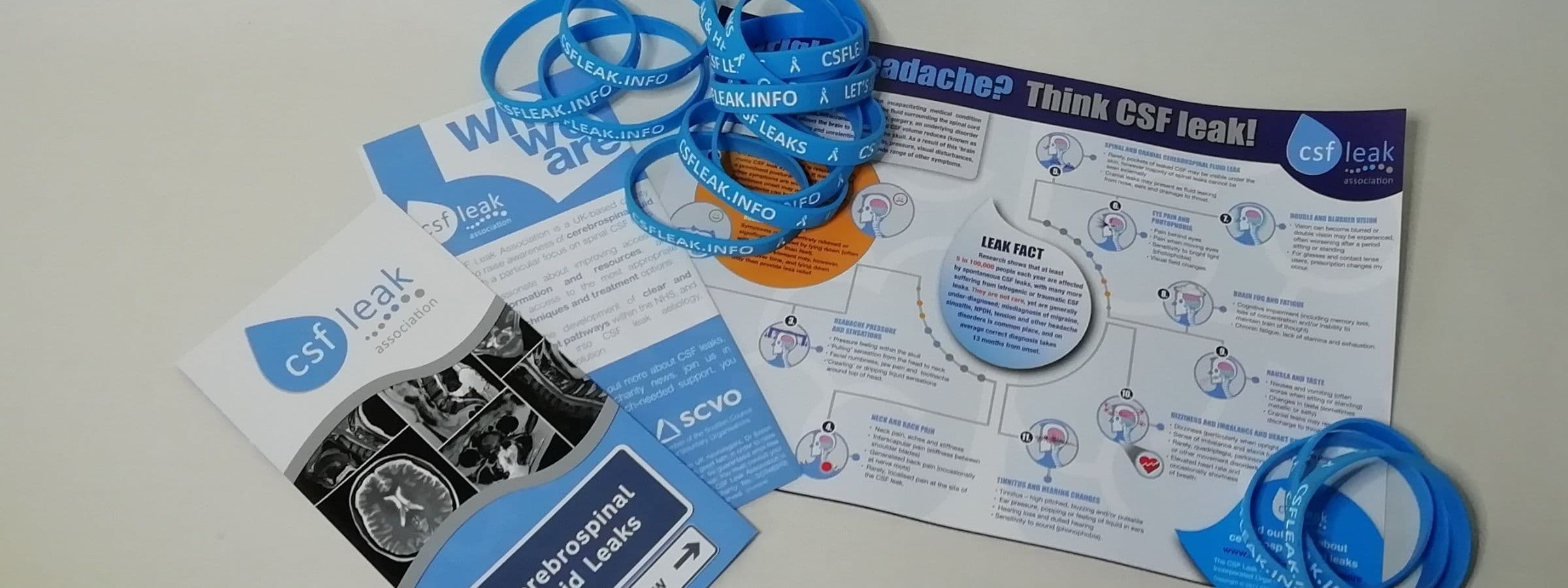 A pile of pamphlets and CSF Leak Association awareness bracelets.