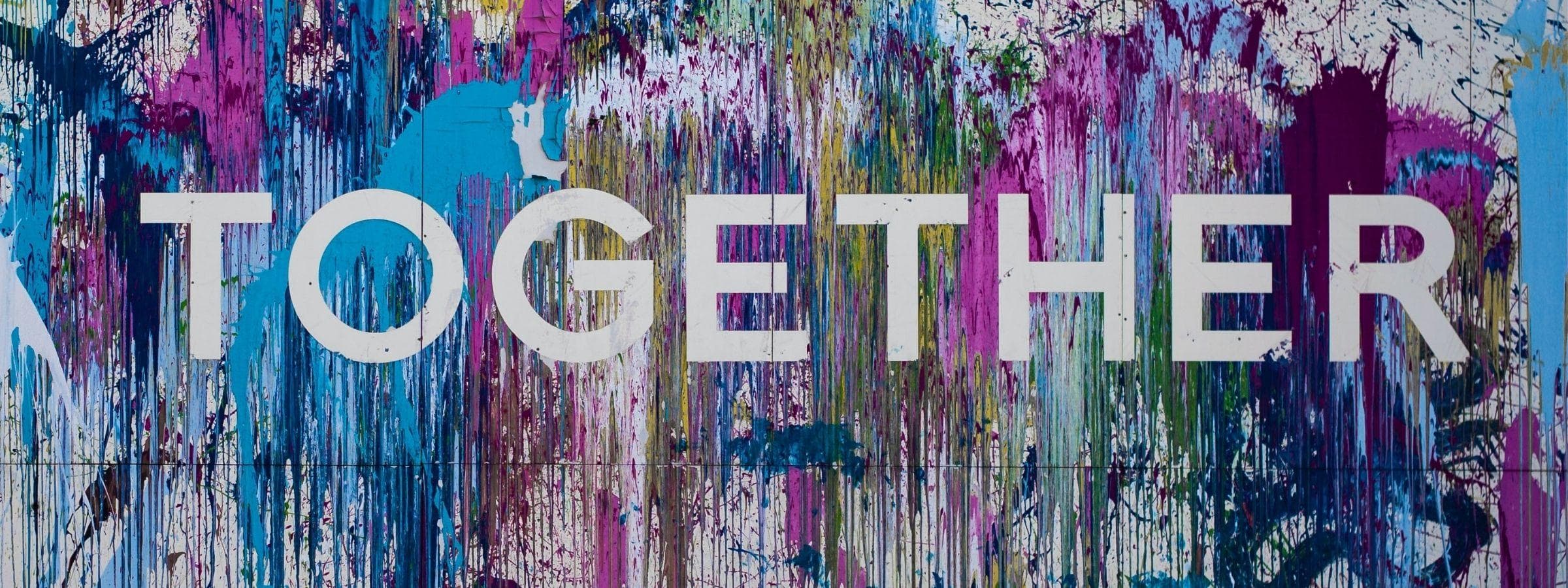 Photo of a wall with streaks of paint with the text "TOGETHER".