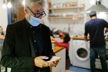 Chef in der Küche Maske und Smartphone