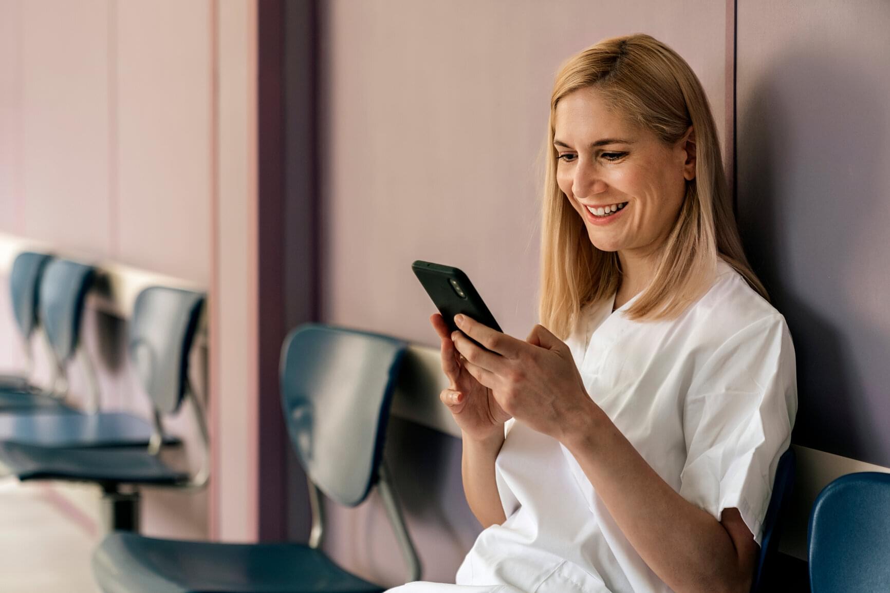 Krankenschwester mittelalt sitzend smartphone Mitarbeiter-App