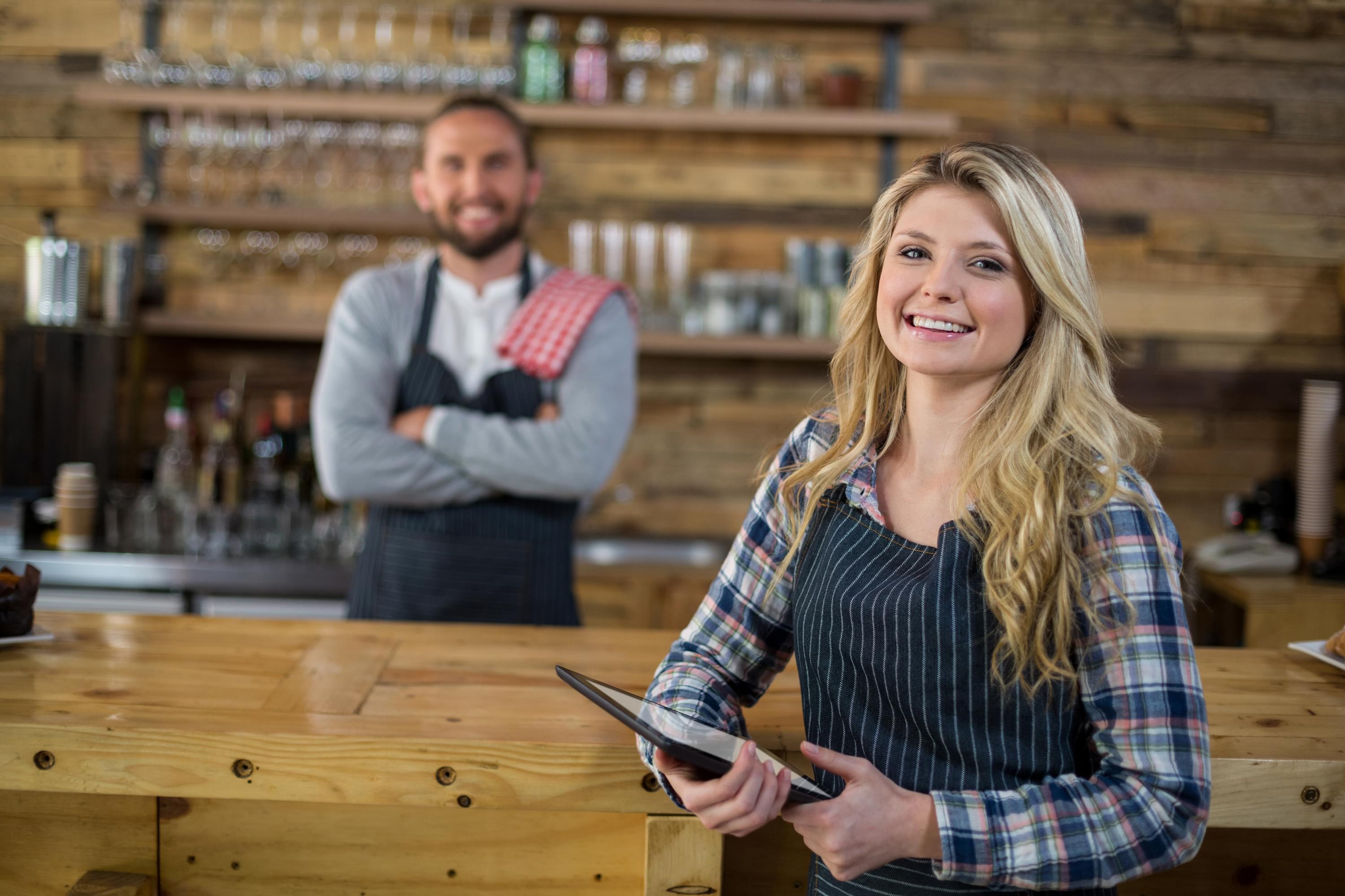 Kellnerin und Barkeeper in Restaurant mit Tablet