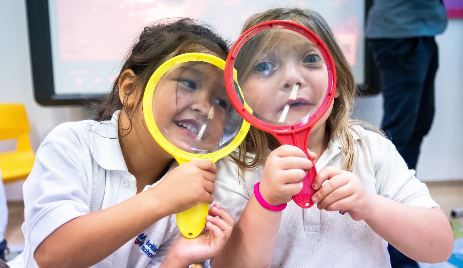 Two students playing with magnifying glass