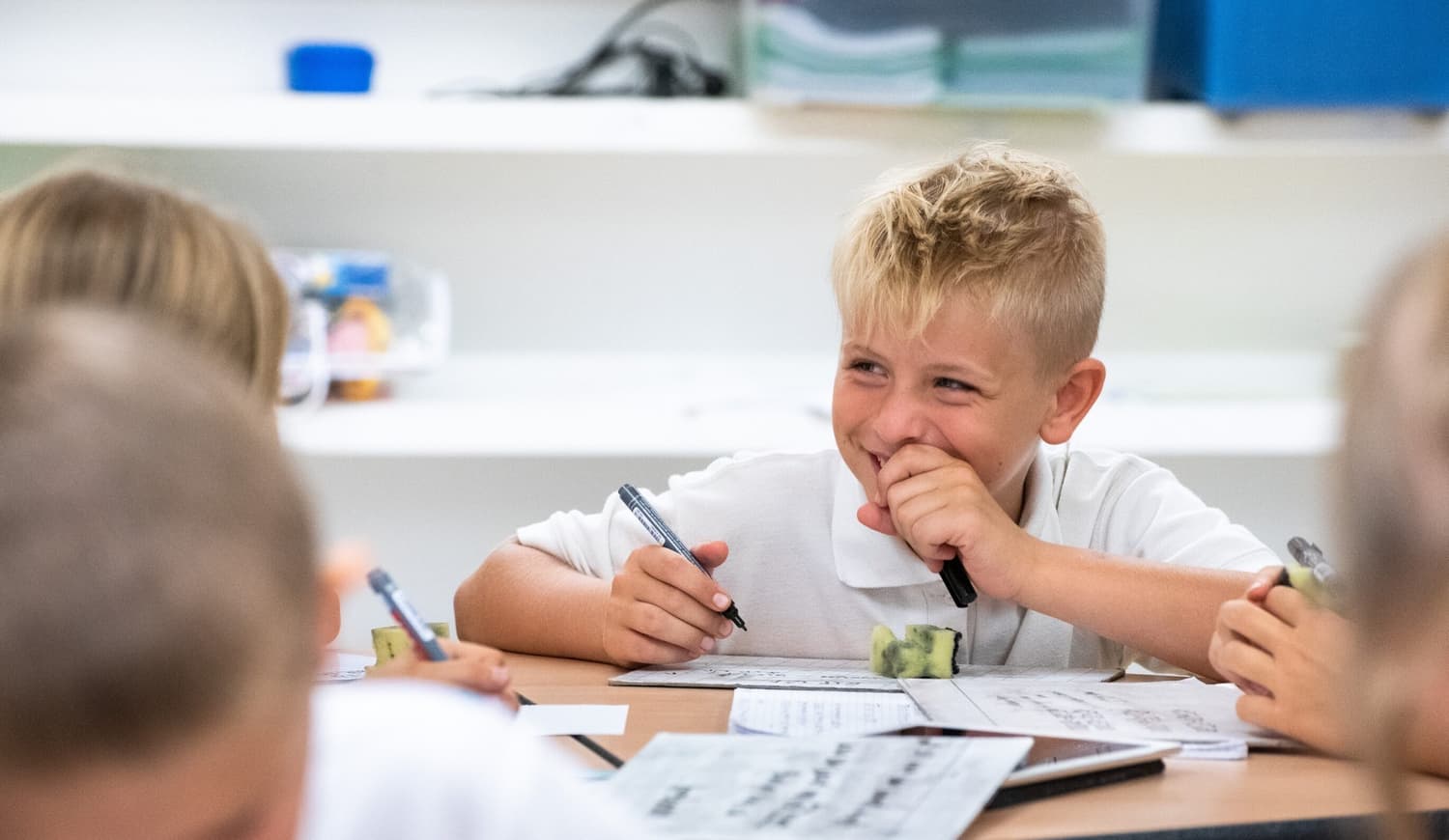 Učenec se smeji v šoli za mizo